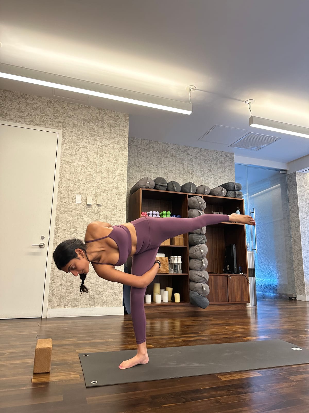 Saniya in a standing balance pose in a yoga studio