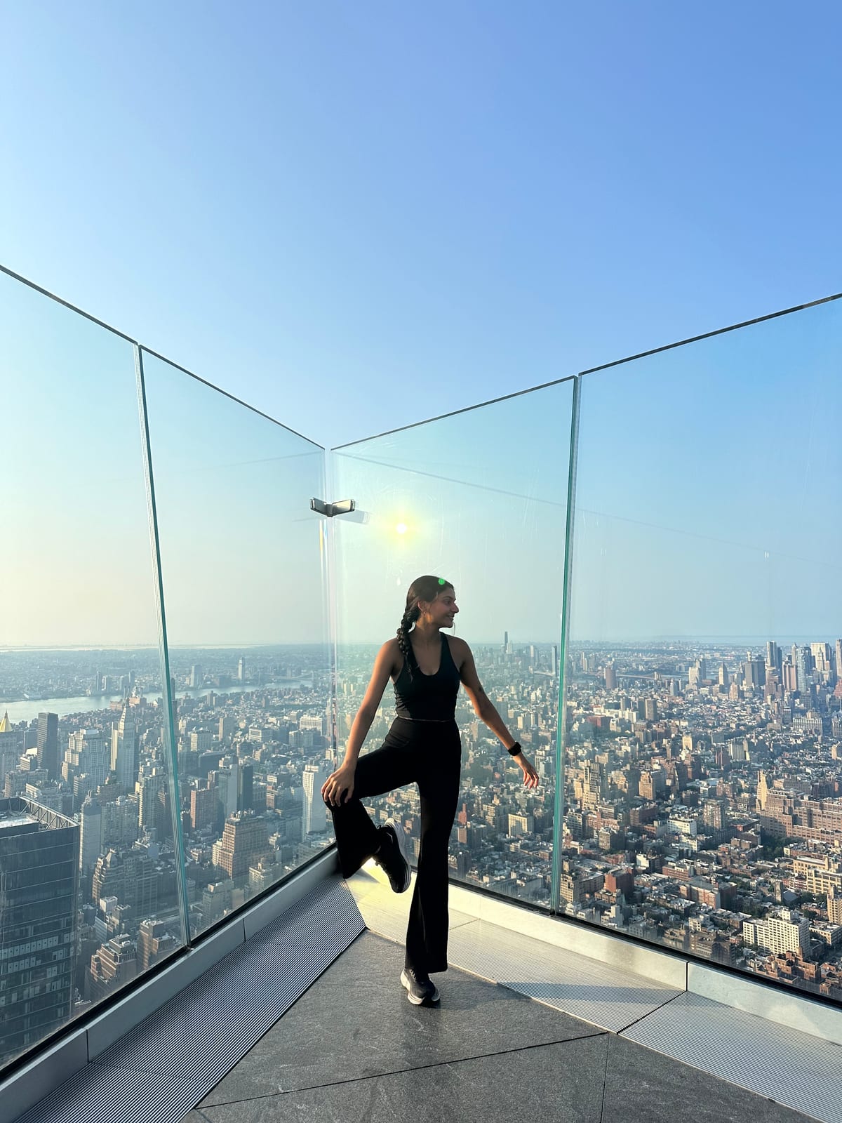 Saniya in a standing balance on an observation deck overlooking the city