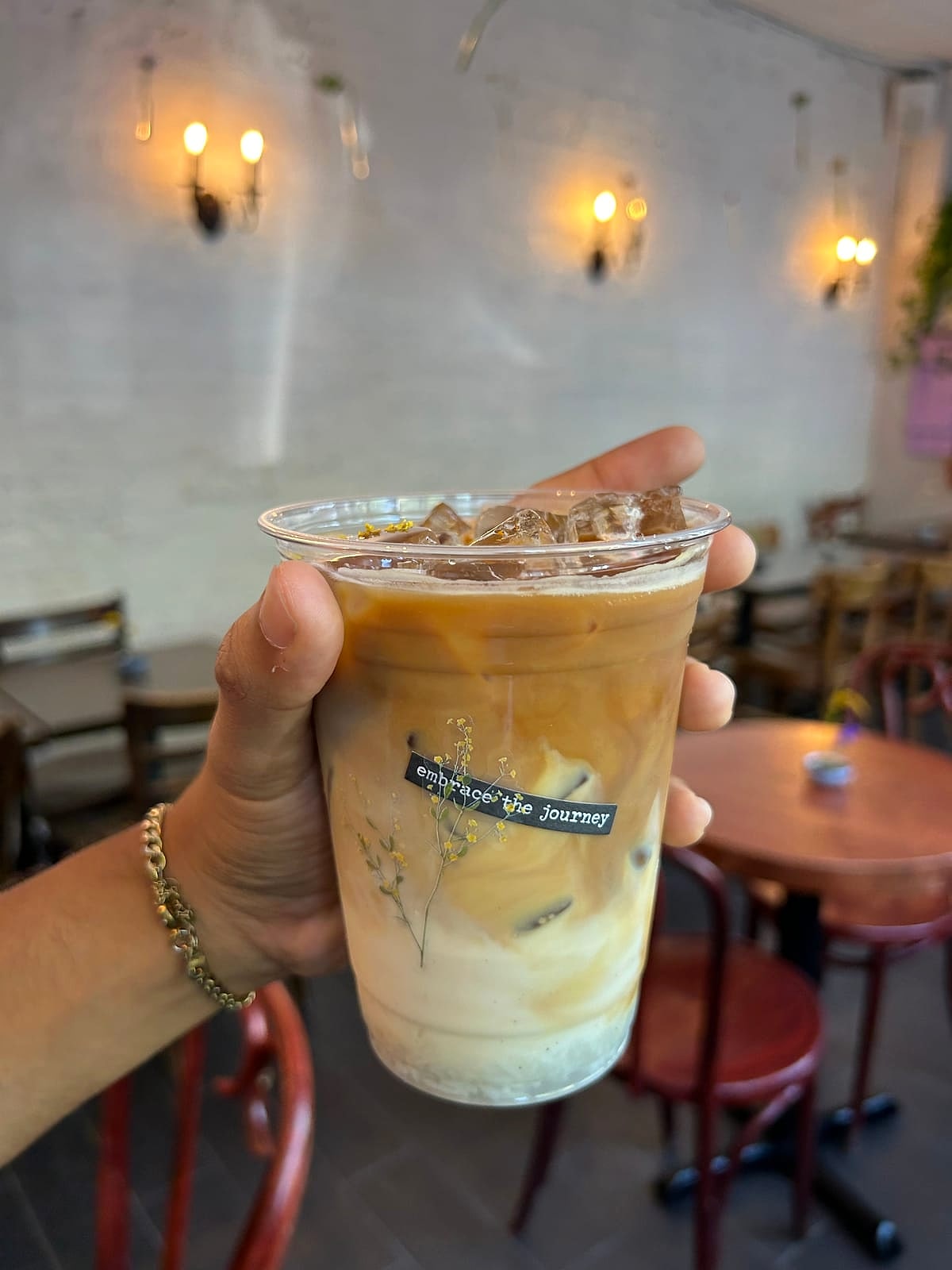 An iced osmanthus latte topped with tiny yellow flowers