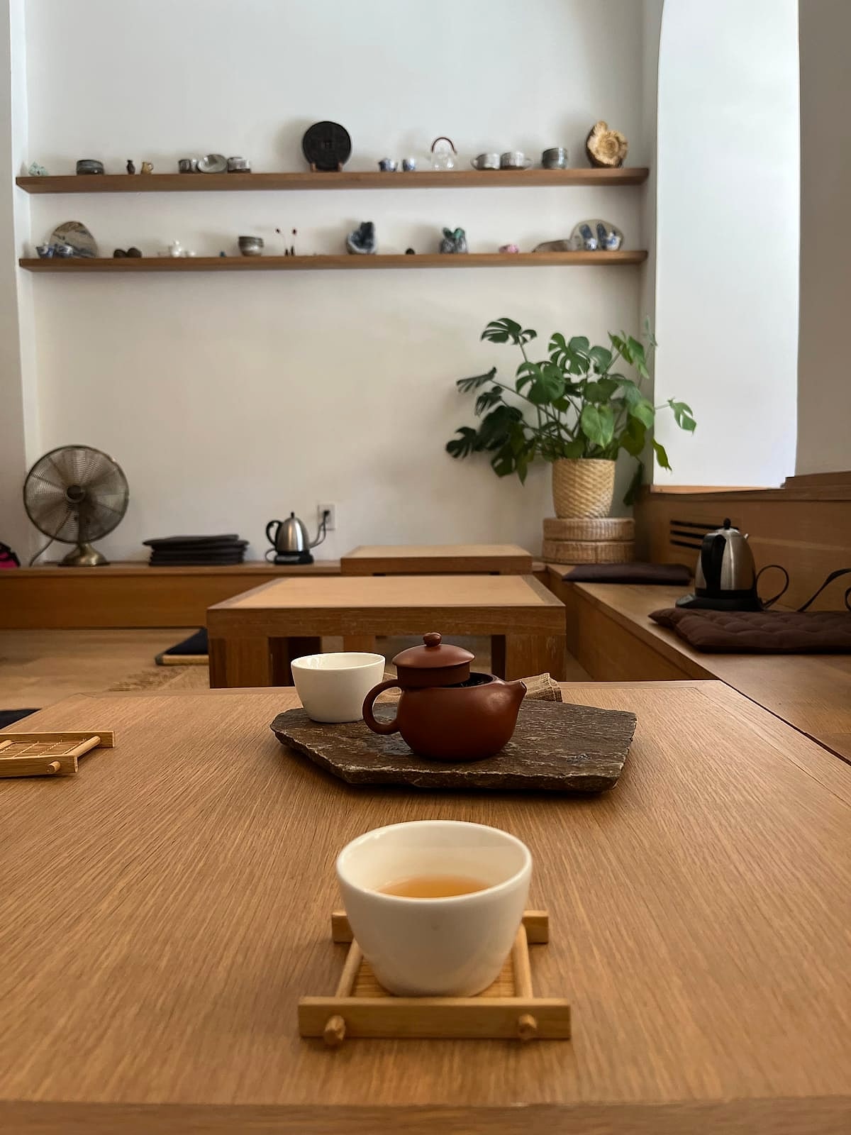 A cup of tea and a clay teapot on a wooden table in the tea room