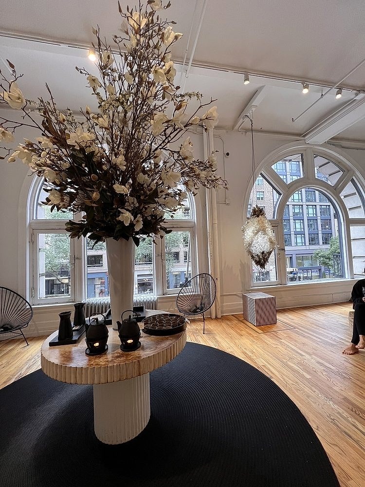 The lobby, with arched windows, a vase of branches and a tea station