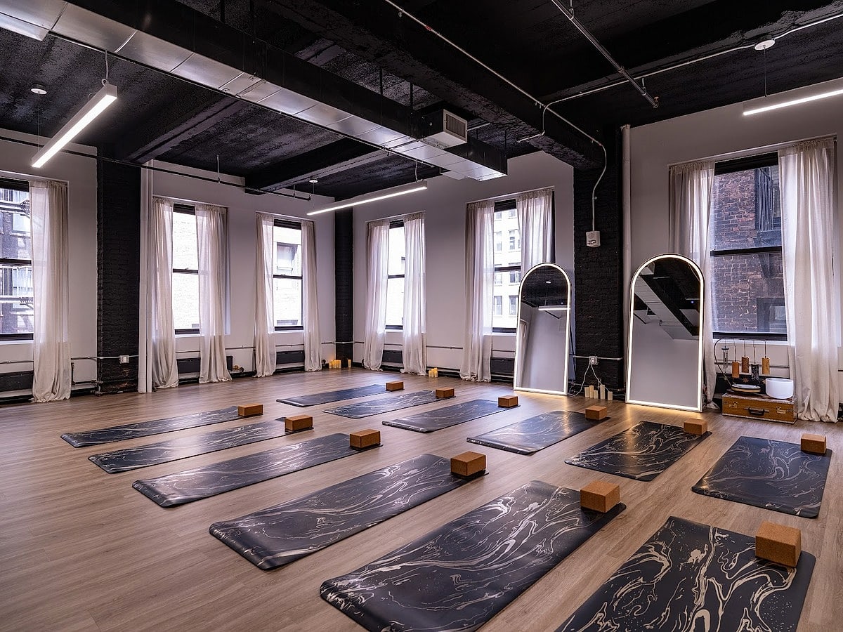 Rows of marbled mats and cork blocks under sheer curtains, with arched mirrors