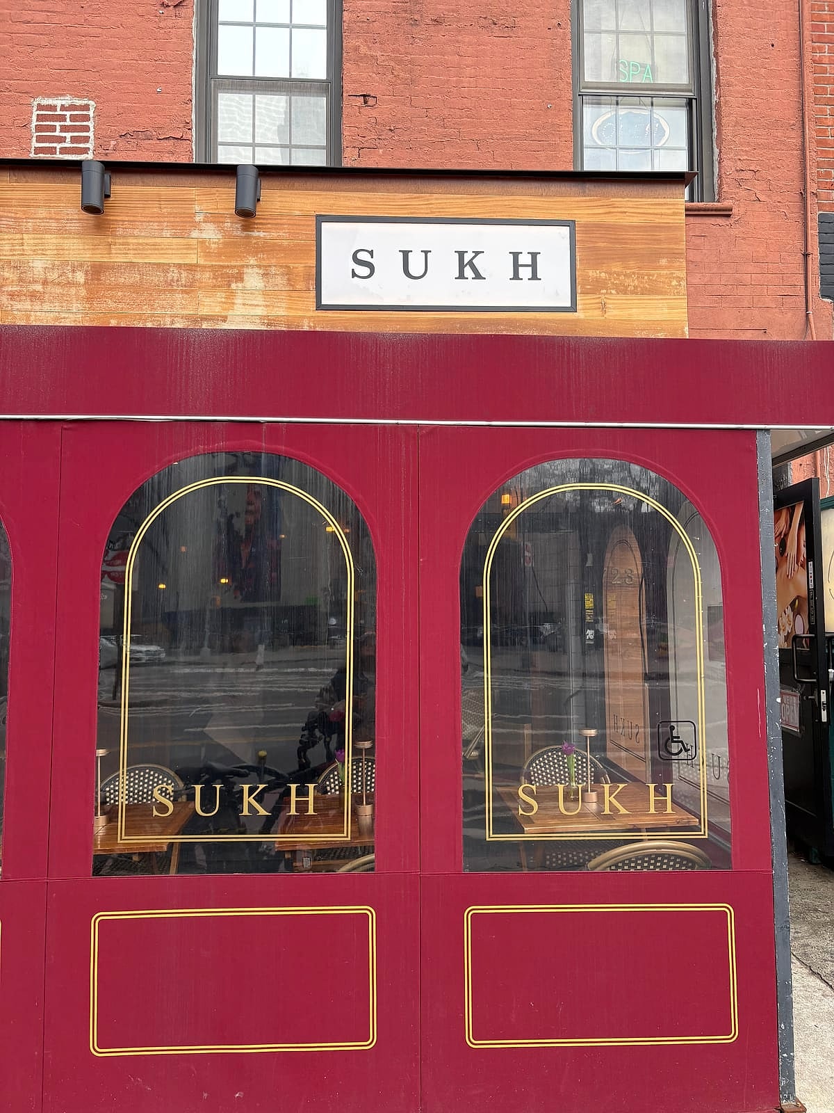 Sukh's red storefront with arched gold-trimmed windows