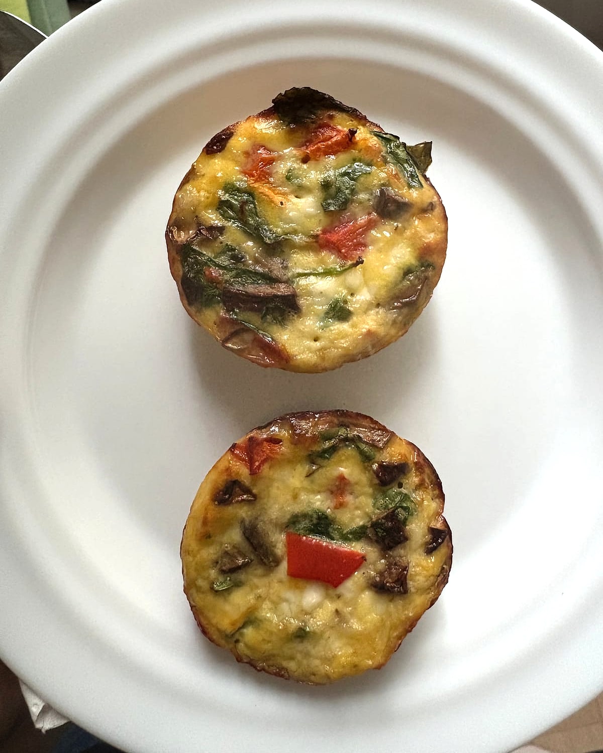 Two baked vegetable egg muffins on a plate
