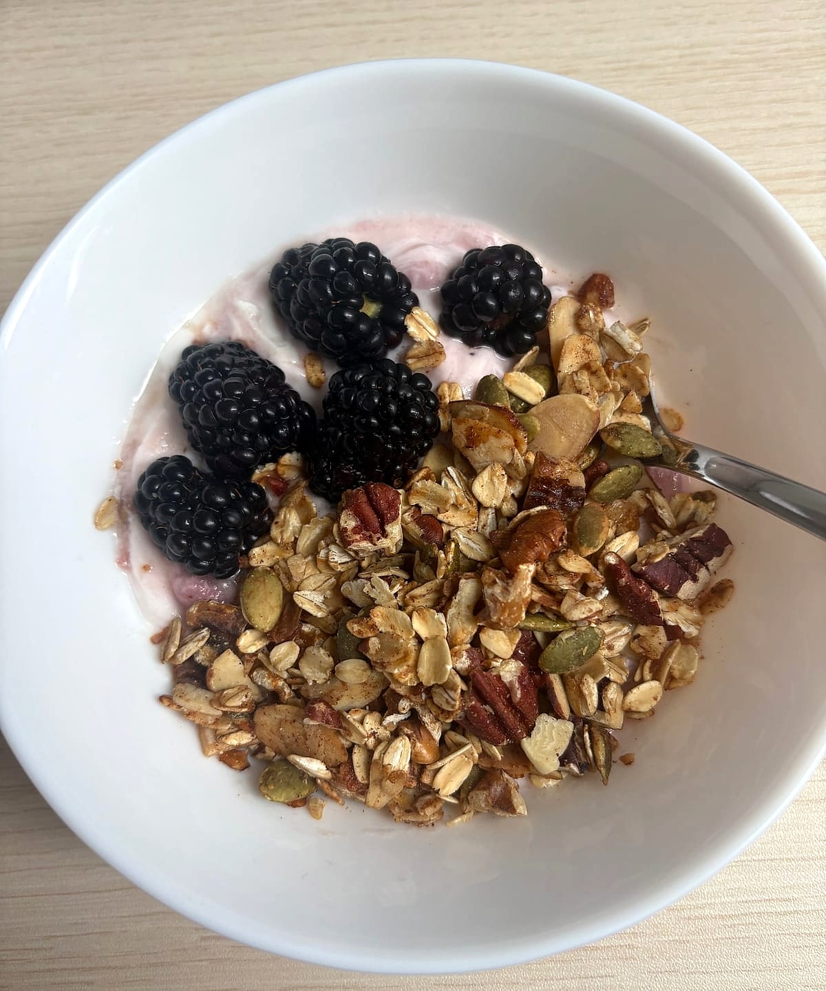 Cashew yogurt topped with homemade granola and blackberries